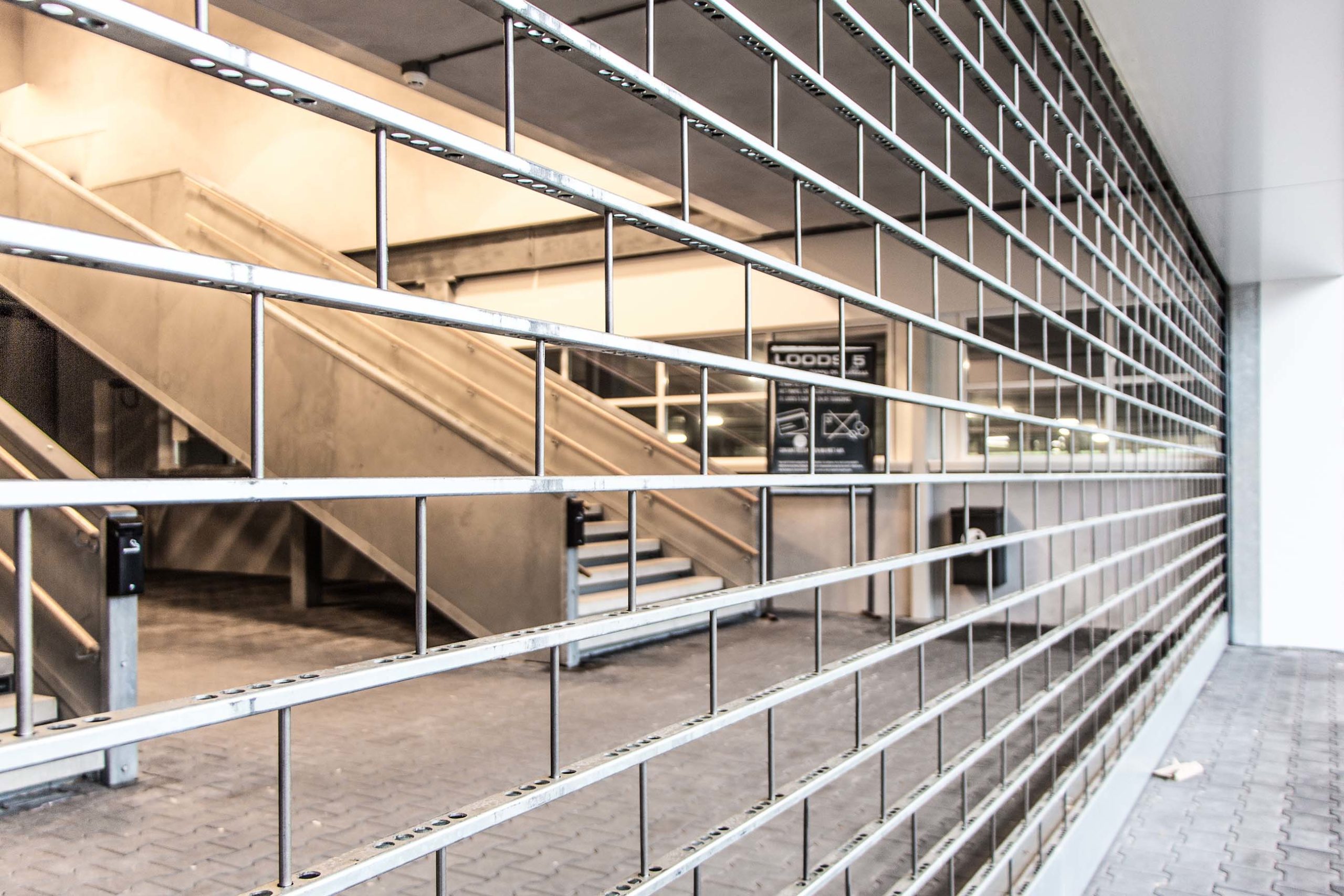 Grille de sécurité métallique devant une cage d’escalier